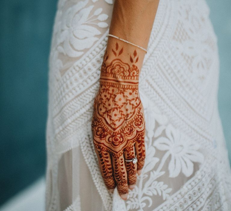 Traditional bridal henna tattoo with elegant pearl bracelet and diamond engagement ring