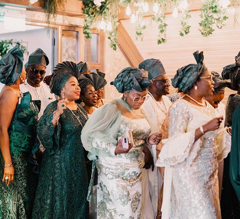 Nigerian wedding guests wearing traditional green Yoruba attire 