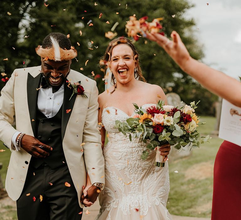 Mermaid off the shoulder lace wedding dress holding sunflower wedding bouquet with groom in white tuxedo 