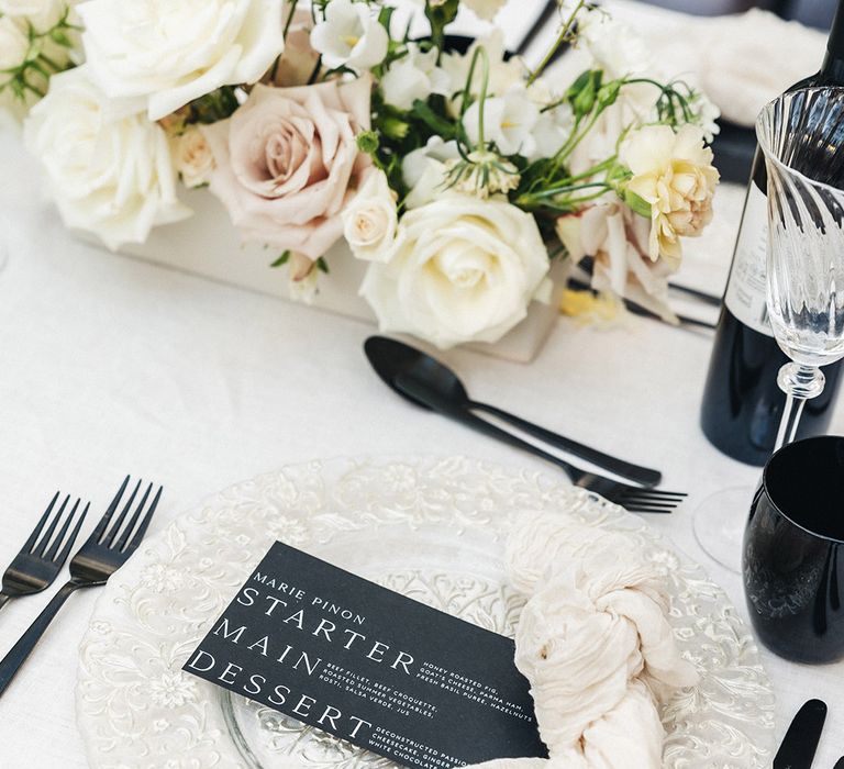 Black and white monochrome wedding place setting with wedding menu sign 