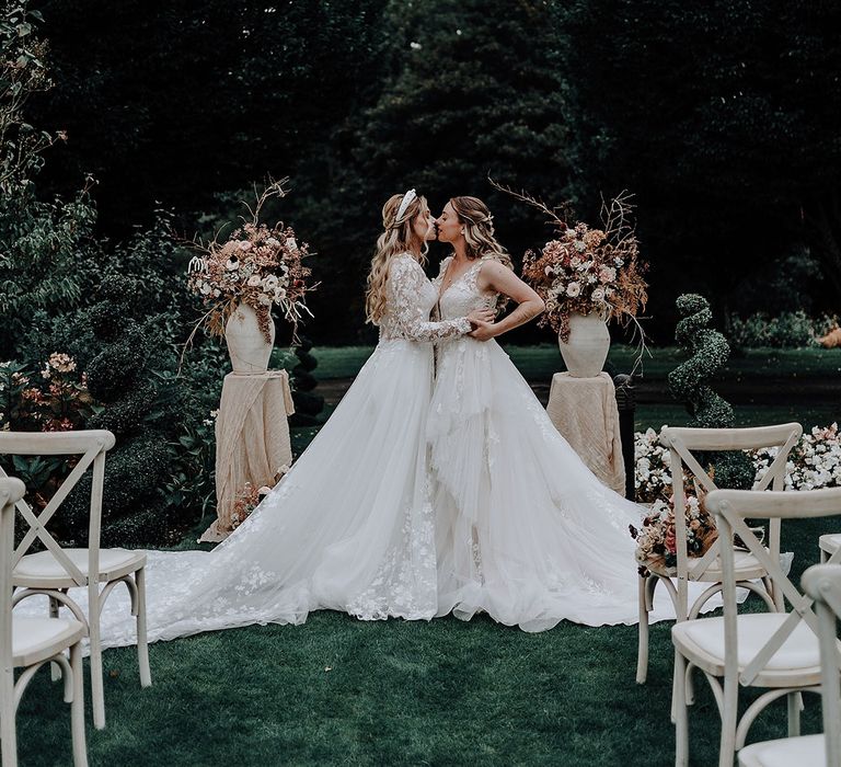 The two brides share a kiss at their garden elopement wedding 