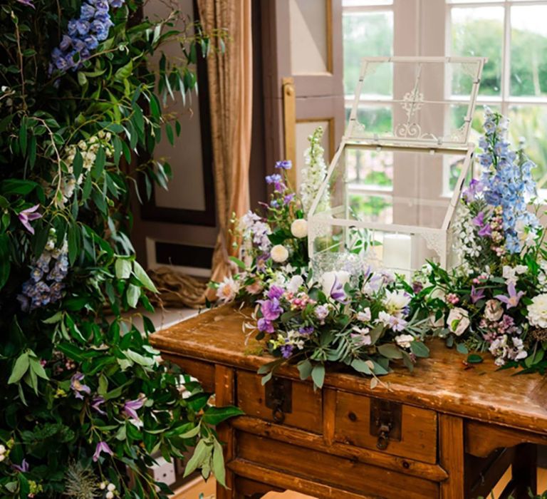 Purple and blue wedding colour palette with whimsical wedding flower arrangements made from lots of foliage 