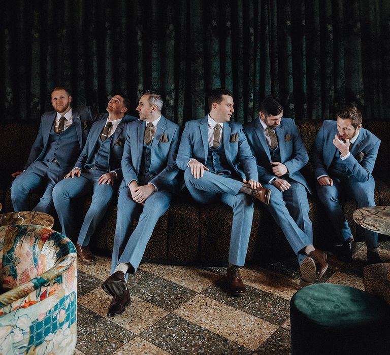 Groom and groomsmen in matching light blue wedding suits 