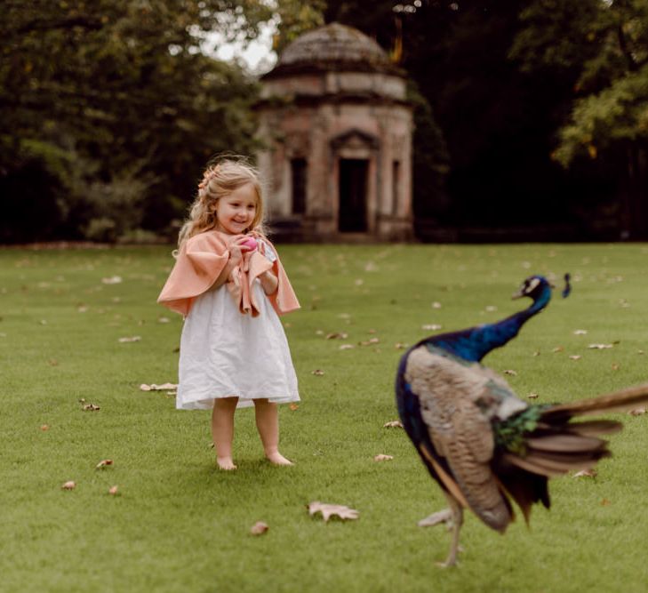 Cute flower girl in pink capelet for Larmer Tree Gardens Wedding