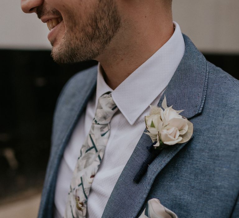 Groom in Blue suit and floral tie with white buttonhole 