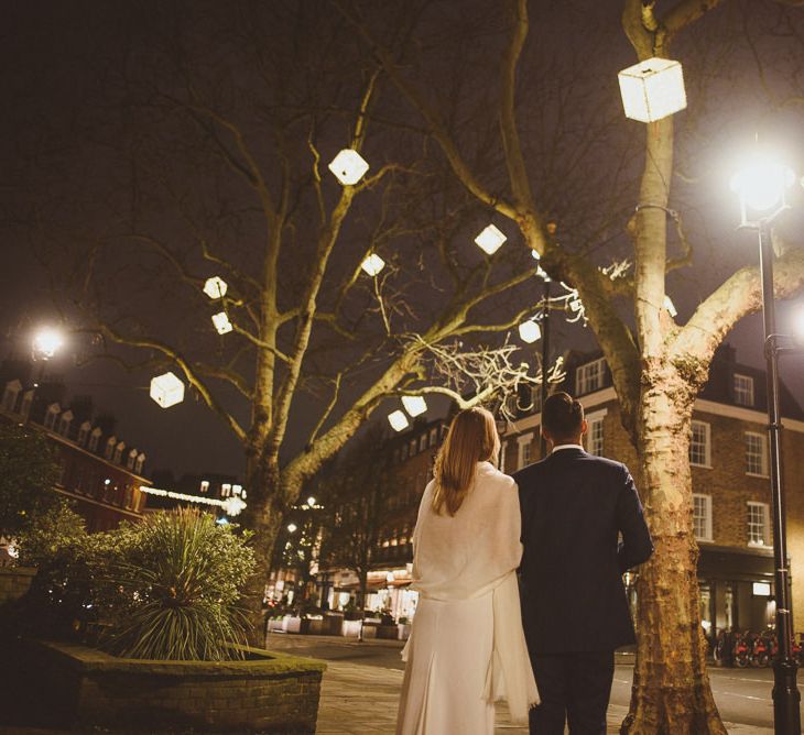 Bride and groom walking into the night outdoor winter wedding photography 