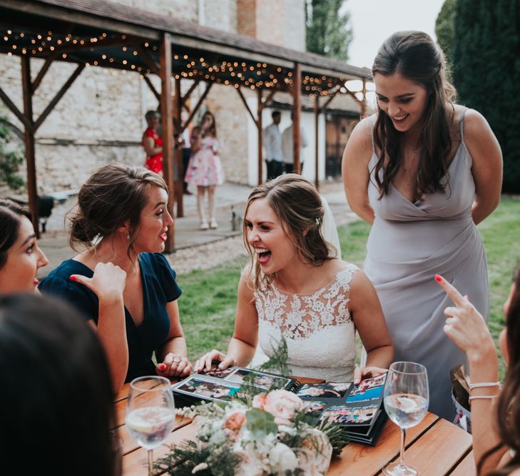 Bride laughing with friends at outdoor drinks reception 