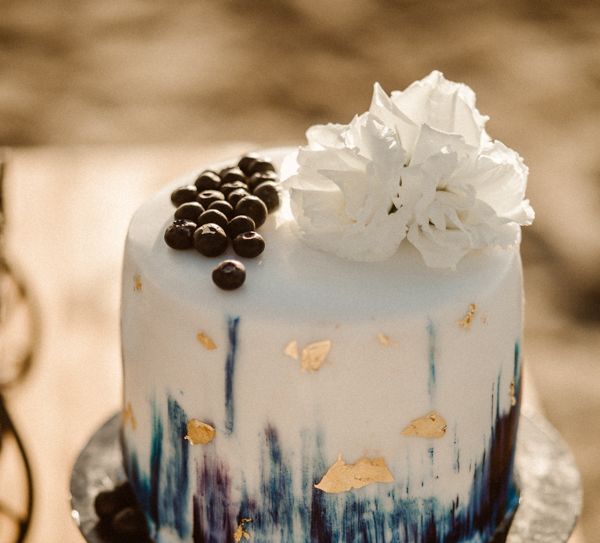 Single tier wedding cake with blue base for beach wedding