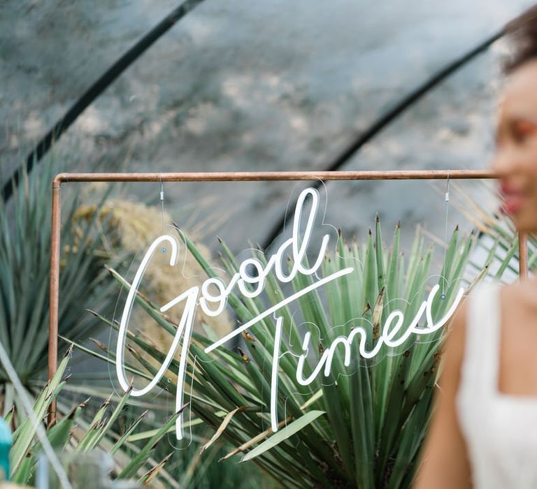 Smiling bride in front of 'Good Times' neon sign at Urban Jungle Suffolk