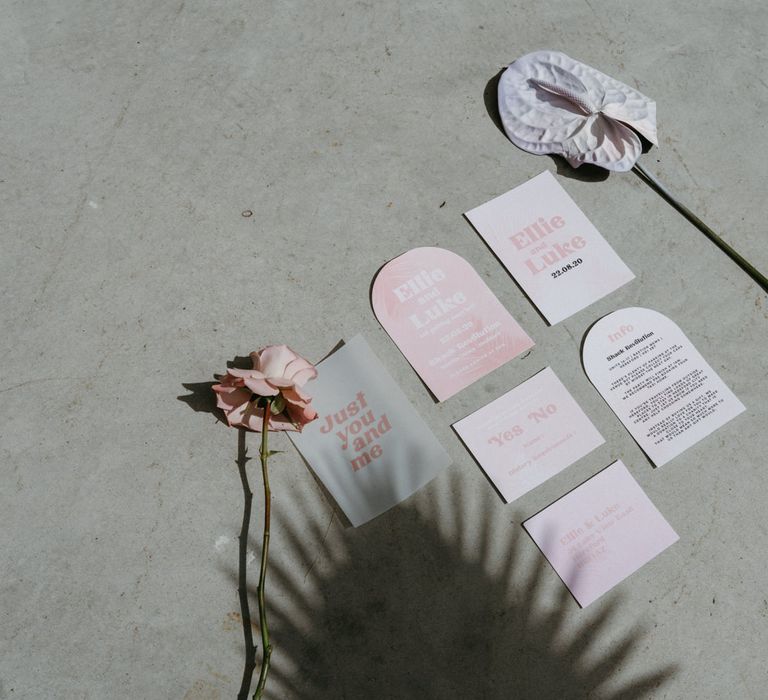 Flatlay of pastel pink wedding stationery suite