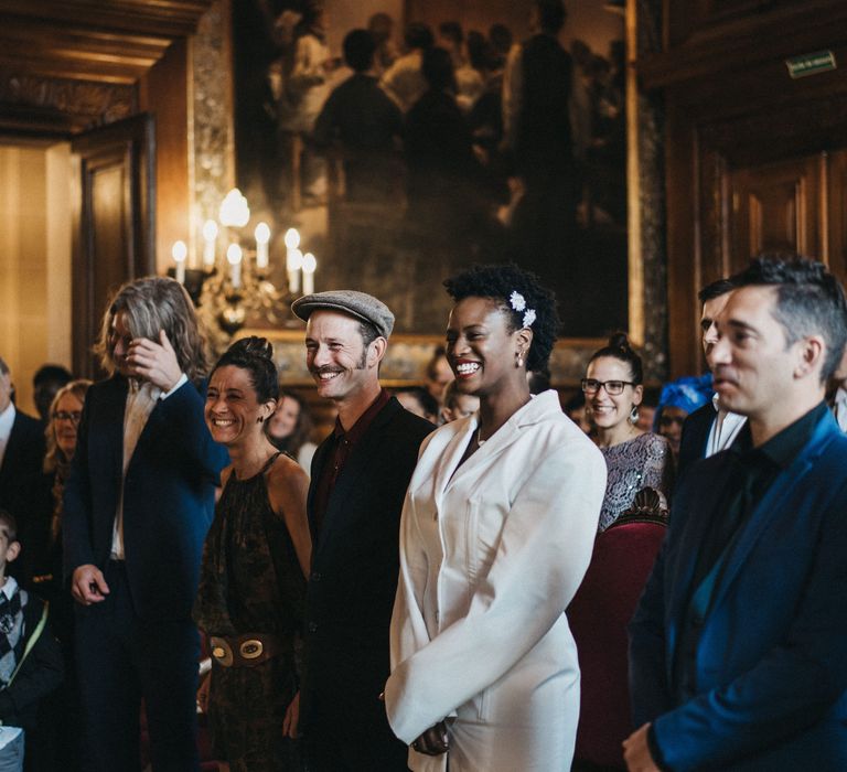 Bride and groom standing at the altar smiling at French town hall wedding 