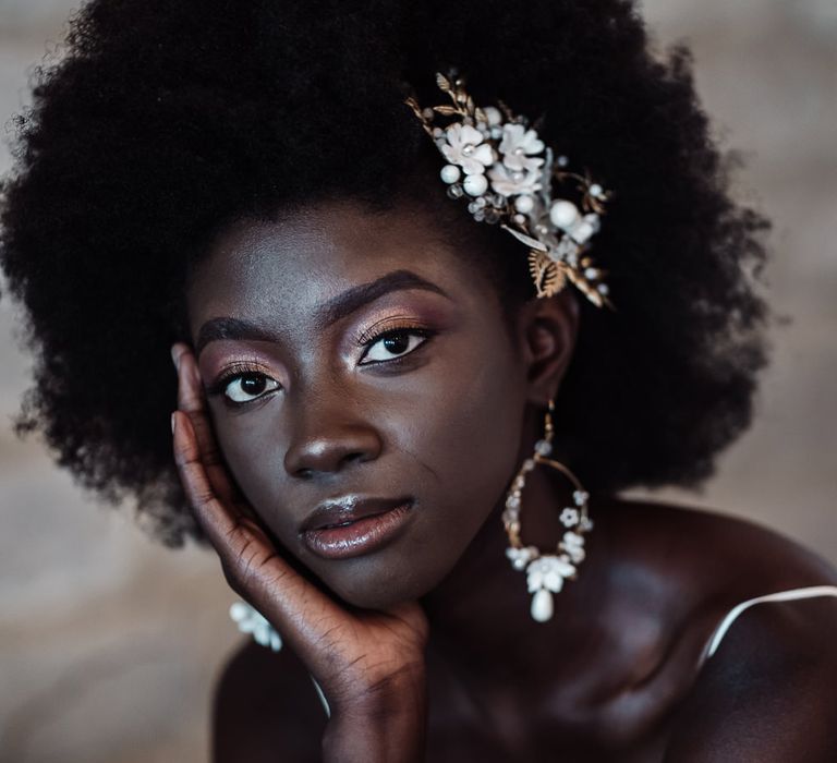 Black bride with afro hair, shimmering eyeshadow and lip gloss bridal makeup 