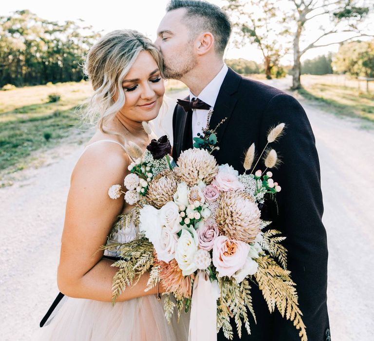 Bride clutches blush bouquet at Australian wedding