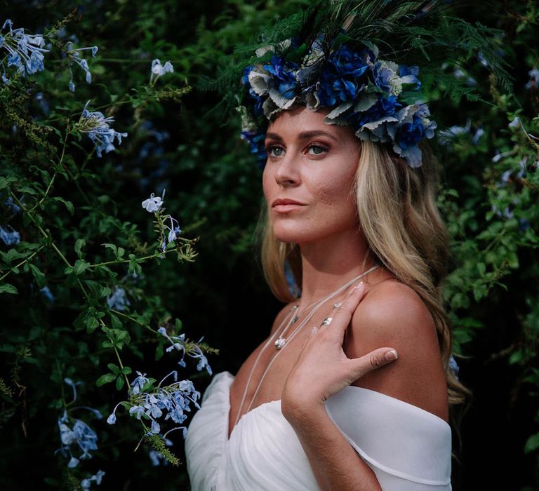 A blonde bride wears bridal separates. The top has a bardot neckline and she wears a flower crown. Photography by Stephanie Shenton.