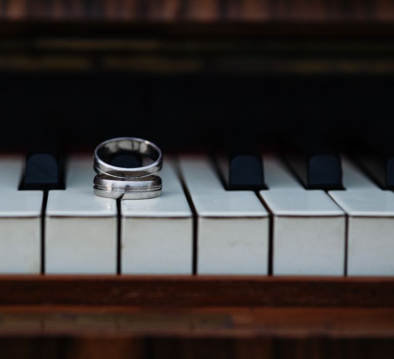 Wedding rings lay upon piano keys