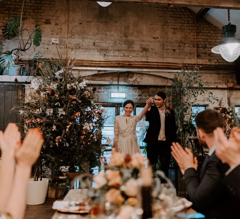 Bride and groom walking into festive wedding venue at Clapton Country Club