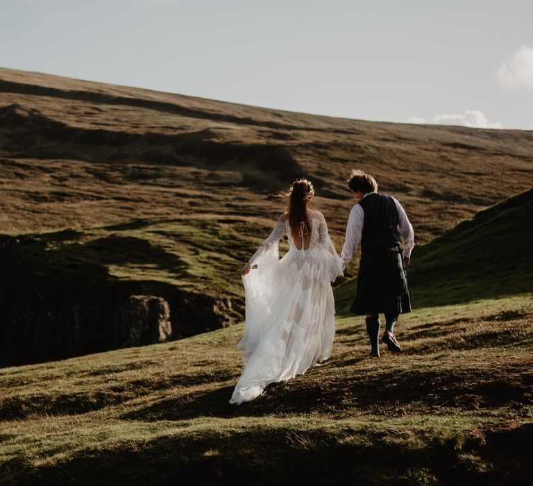 Bride & groom walk across the hillside for elopement