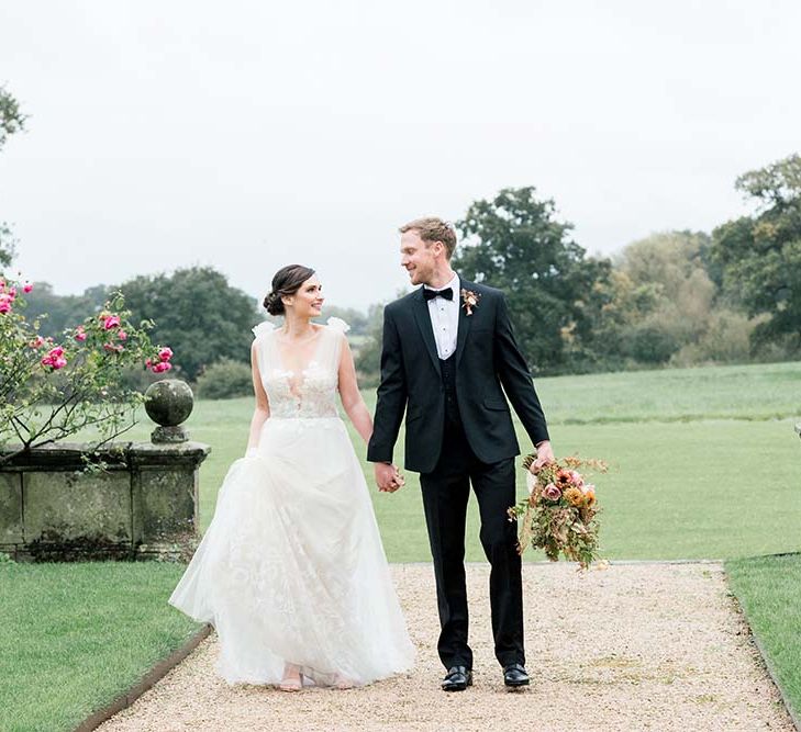 Black tie wedding with groom in a tuxedo and bride in a romantic tulle and lace wedding dress 