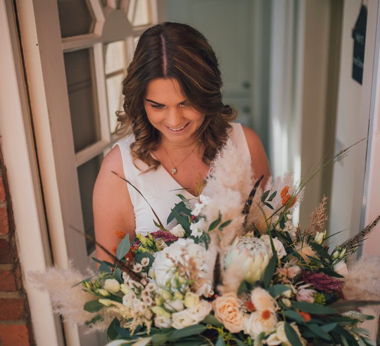 Bride holds floral bouquet on the morning of her wedding day