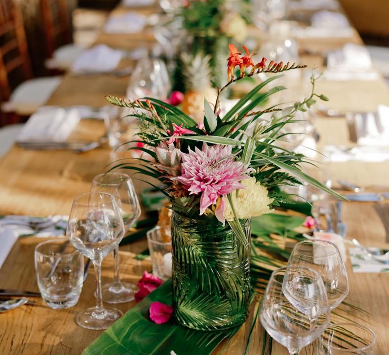 Vibrant flower and tropical leaf wedding table decor