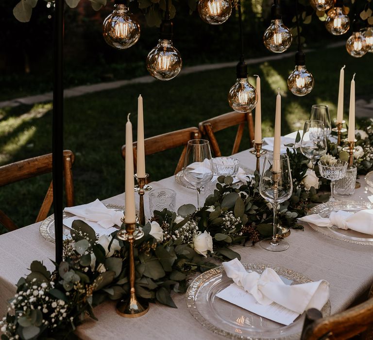 Foliage and white rose table runner and installation at intimate wedding reception table 