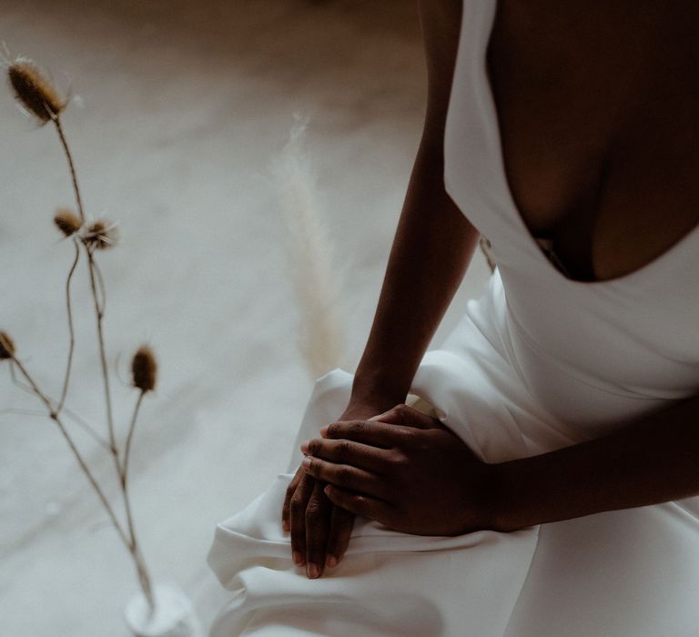 Close up of a brides hands placed on her lap.