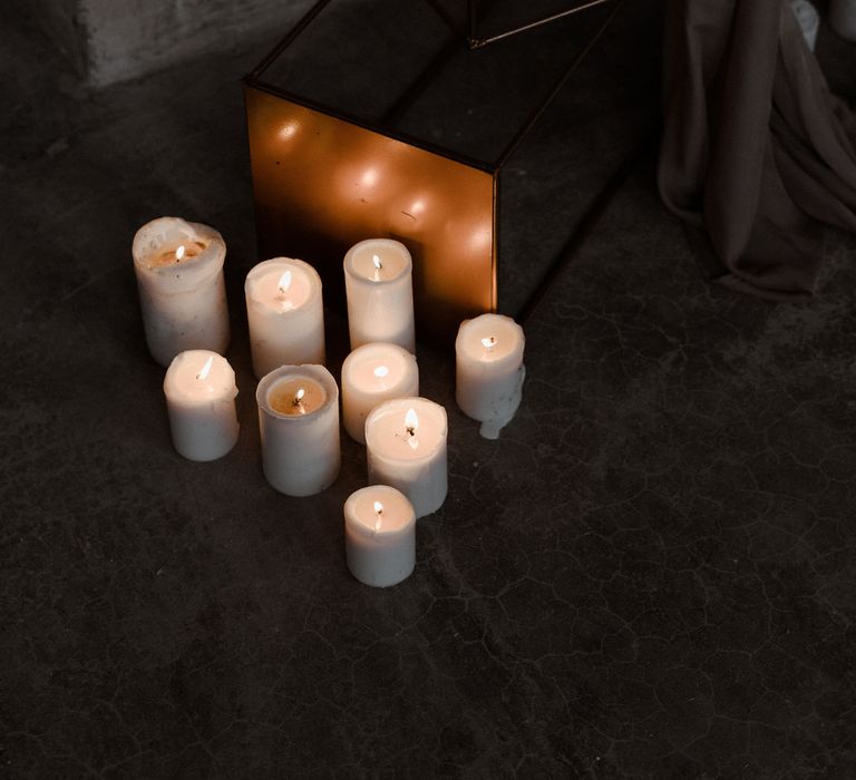 Lit candles sit at the base of a cake podium stand.