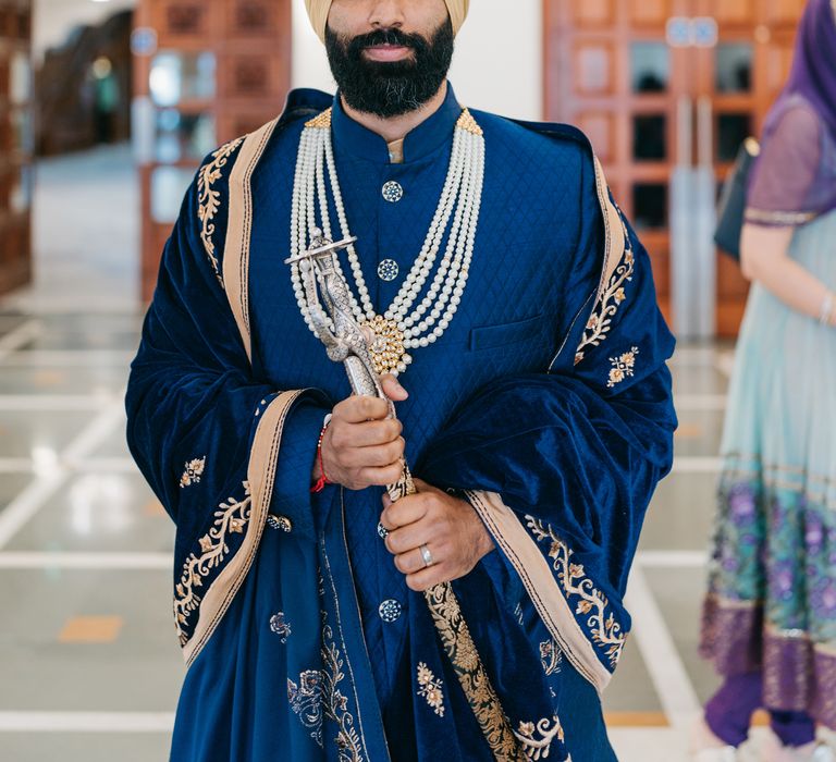 Groom wears royal blue on his wedding day with gold embellishment 