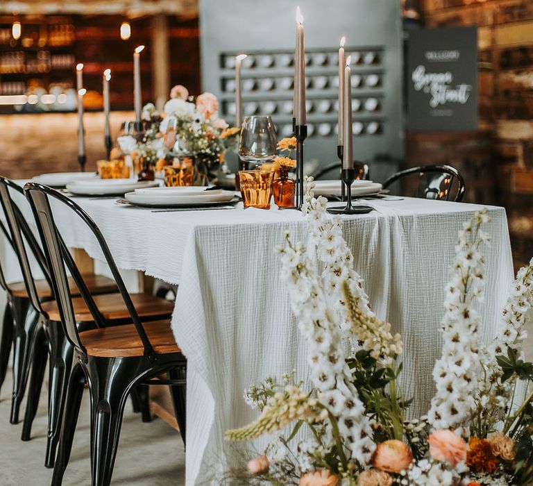 taupe taper candles in black candlesticks at rustic wedding venue, Gyhll Barn in the Lake District 