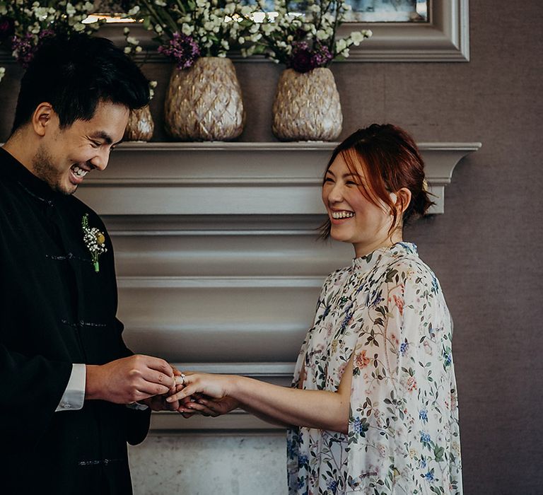 East Asian bride and groom holding hands during the intimate wedding ceremony at Old Marylebone Town Hall 