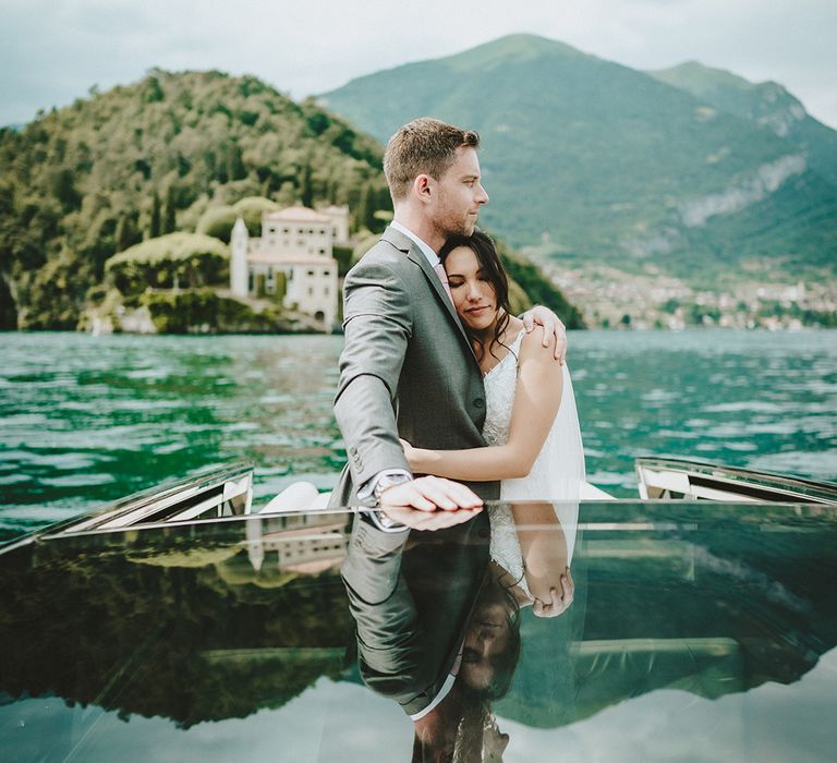 Bride leans her head into groom on her wedding day as they sail across Lake Como