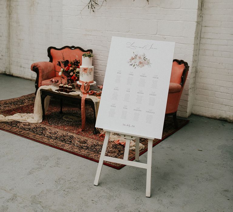 Wedding seating chart with pink floral design on a wooden easel for minimalist industrial shoot at Gage Gallery 