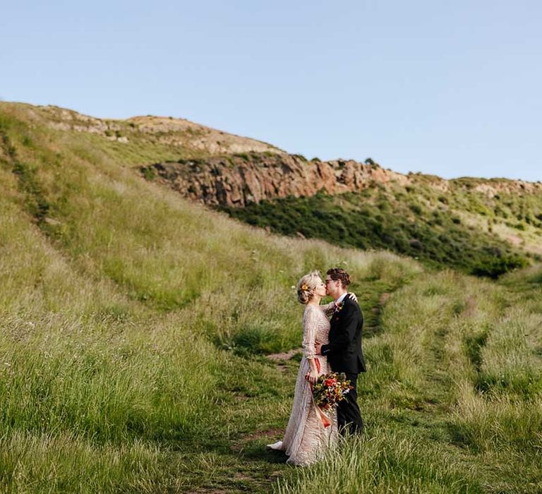 Bride & groom walk up hillside on their wedding day in Scotland