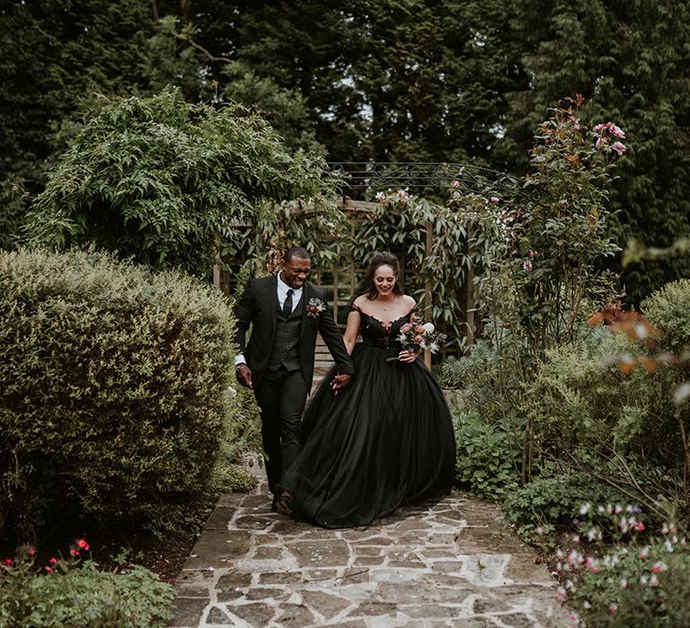 Bride & groom walk through gardens on their wedding day