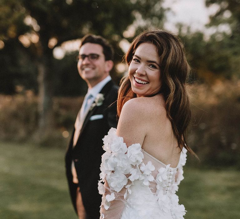 Bride smiles in off the shoulder wedding dress