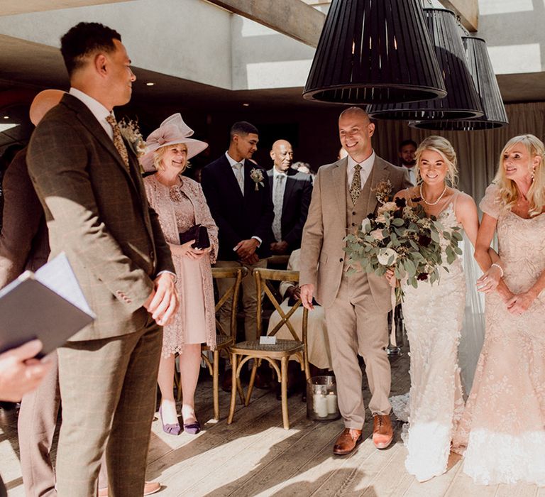 Bride's parents walk the bride down the aisle for intimate wedding ceremony