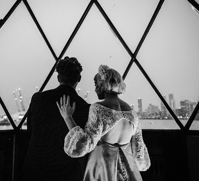 Bride and groom overlook the skyline of London with view of the Millennium Dome