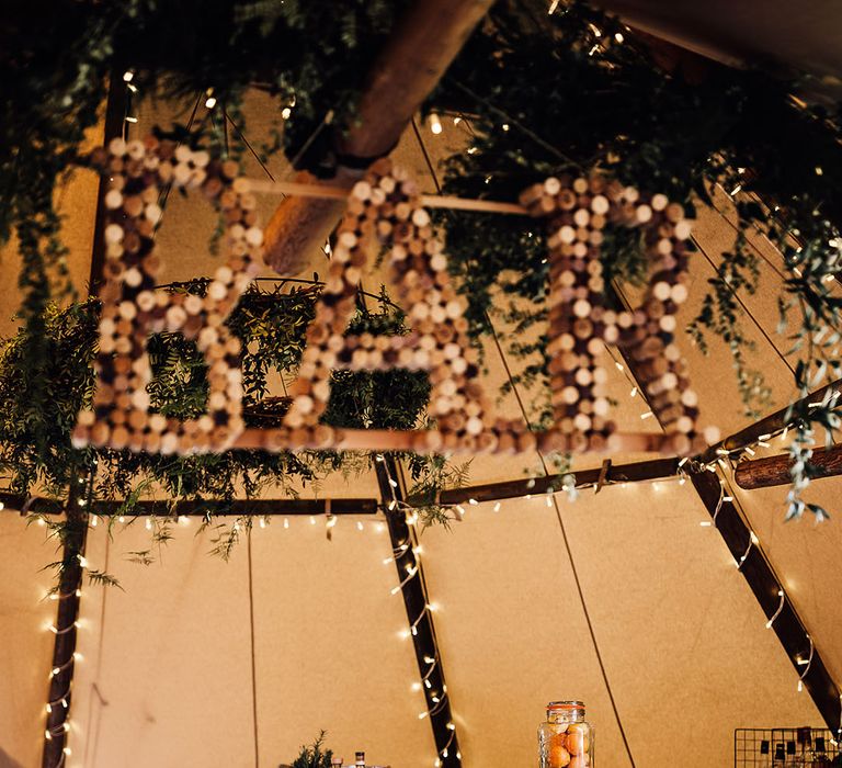 Bar area with bottles of water, juices, fruits and alcohol in tent for wedding reception 