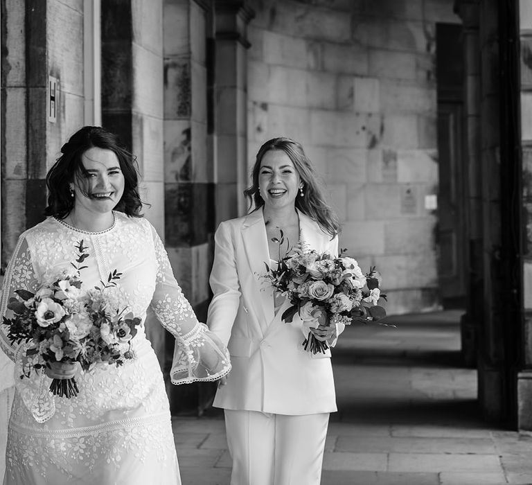 Brides hold hands in black and white image 