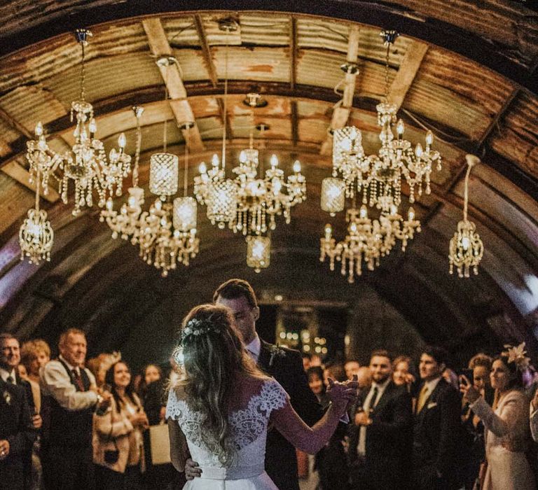 Bride and groom first dance at Anna in Devon with handing chandeliers on the dance floor 