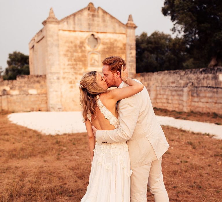 Bride and groom share a kiss on their wedding day in Puglia, Italy