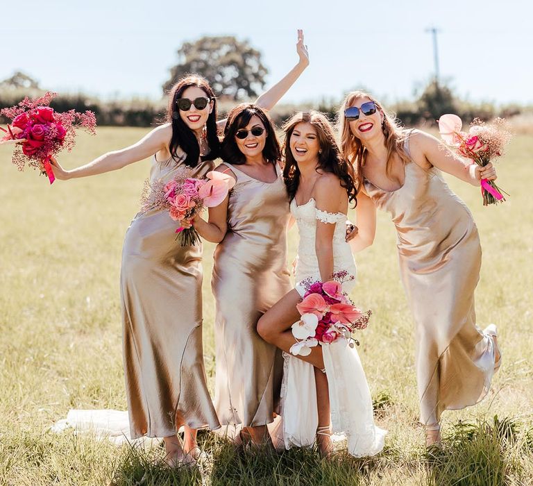 Fun wedding with the bridesmaids in sparkly metallic dresses with bright pink bouquets