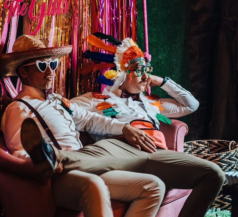 Flower dudes in funny hats and sunglasses in front of streamer backdrop and custom sign 