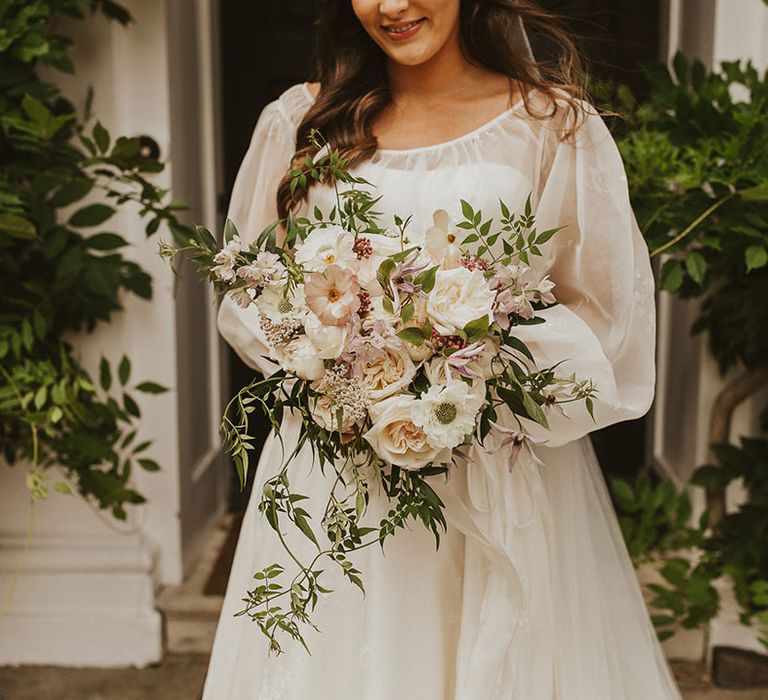 Bride holding a pretty and delicate pink and white wedding bouquet 