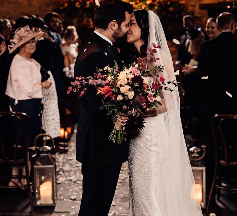 The bride and groom lean in for a kiss together on their wedding day 