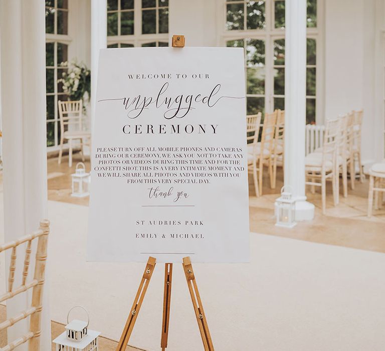 White wedding signage for unplugged wedding ceremony on wooden easel 