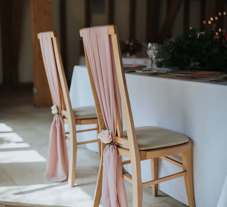 Blush pink wedding chair sash tied in the middle with a pink rose for pink theme wedding 