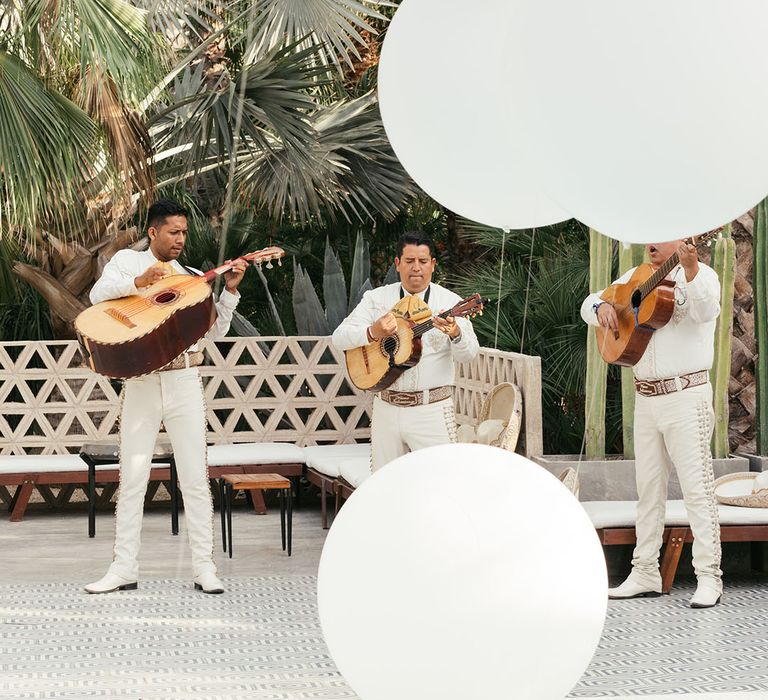 Mariachi band plays outdoors beside pool 