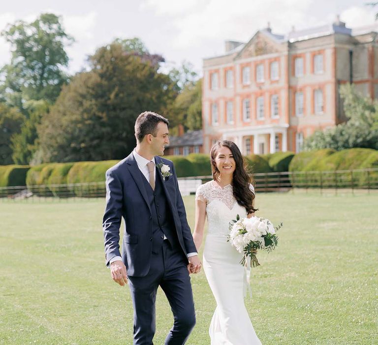 Classic wedding at Ardington House with bride in a fitted wedding dress with lace illusion neckline and groom in a navy suit