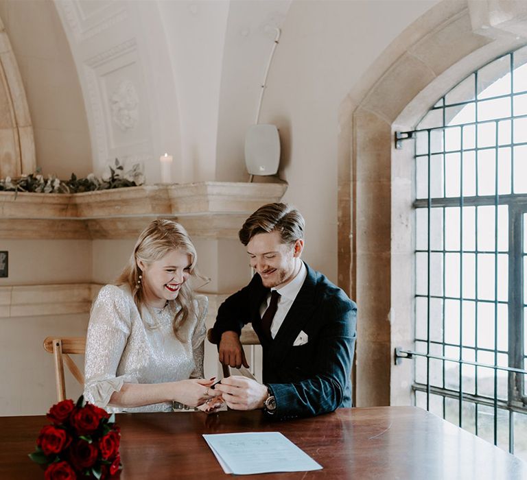 The bride and groom sign the register at Normanton Church for their gothic Halloween wedding 